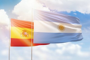 Sunny blue sky and flags of argentina and spain