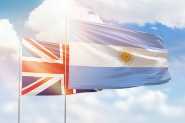 Sunny blue sky and flags of argentina and united kingdom
