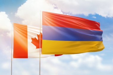 Sunny blue sky and flags of armenia and canada