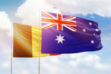 Sunny blue sky and flags of australia and belgium