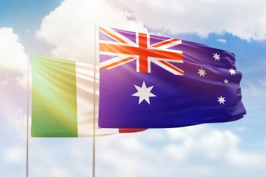Sunny blue sky and flags of australia and italy