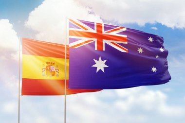 Sunny blue sky and flags of australia and spain