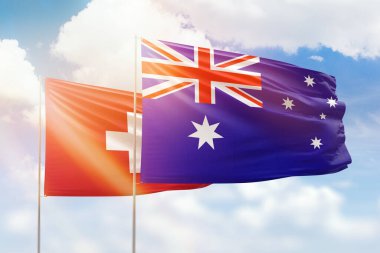 Sunny blue sky and flags of australia and switzerland