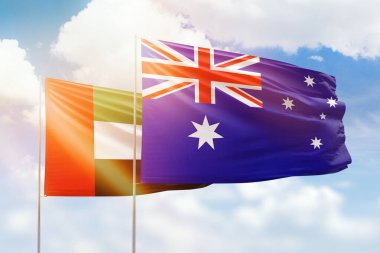 Sunny blue sky and flags of australia and uae