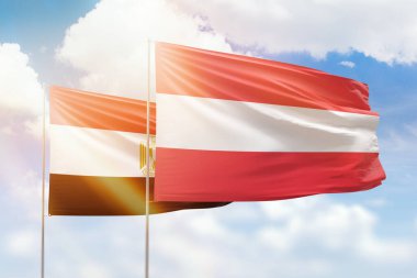 Sunny blue sky and flags of austria and egypt
