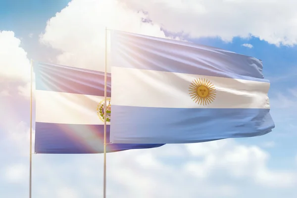 Sunny blue sky and flags of argentina and el salvador