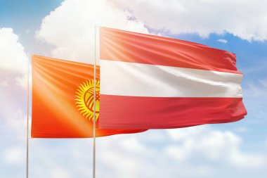 Sunny blue sky and flags of austria and kyrgyzstan