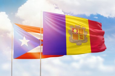 Sunny blue sky and flags of andorra and puerto rico