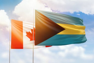 Sunny blue sky and flags of bahamas and canada