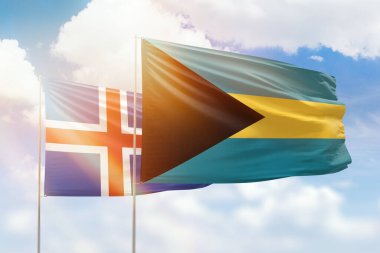 Sunny blue sky and flags of bahamas and iceland
