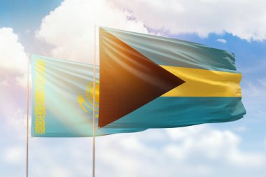 Sunny blue sky and flags of bahamas and kazakhstan