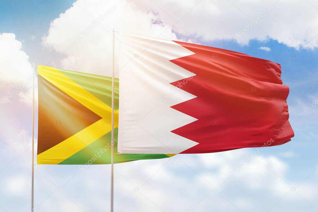 Sunny blue sky and flags of bahrain and jamaica