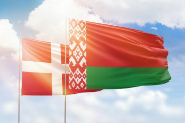Sunny blue sky and flags of belarus and denmark