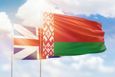 Sunny blue sky and flags of belarus and great britain