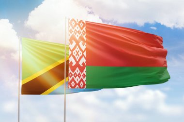 Sunny blue sky and flags of belarus and tanzania