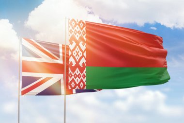 Sunny blue sky and flags of belarus and united kingdom