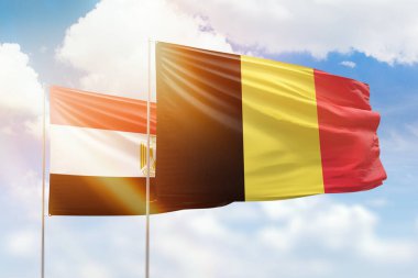 Sunny blue sky and flags of belgium and egypt