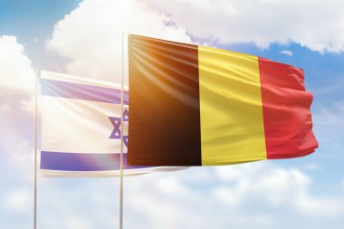 Sunny blue sky and flags of belgium and israel