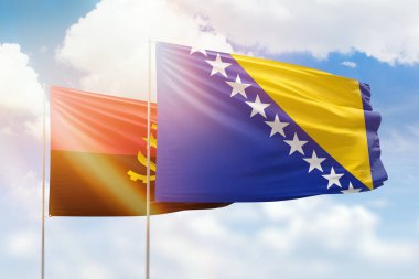 Sunny blue sky and flags of bosnia and angola