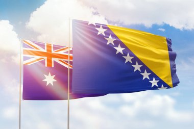 Sunny blue sky and flags of bosnia and australia