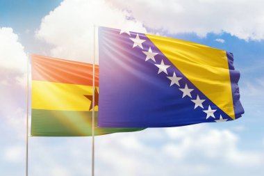 Sunny blue sky and flags of bosnia and ghana