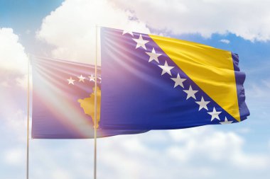 Sunny blue sky and flags of bosnia and kosovo