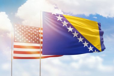 Sunny blue sky and flags of bosnia and usa