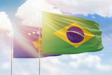 Sunny blue sky and flags of brazil and kosovo