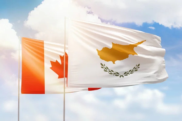 Sunny blue sky and flags of cyprus and canada