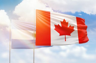 Sunny blue sky and flags of canada and argentina