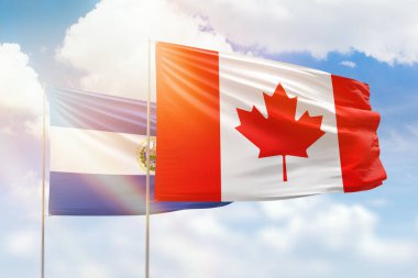 Sunny blue sky and flags of canada and el salvador