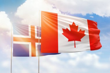 Sunny blue sky and flags of canada and iceland
