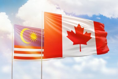 Sunny blue sky and flags of canada and malaysia