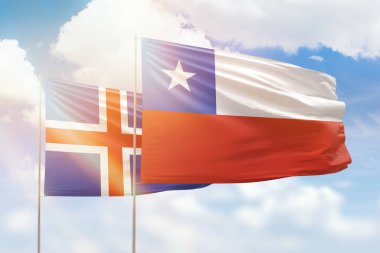 Sunny blue sky and flags of chile and iceland