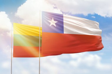 Sunny blue sky and flags of chile and lithuania