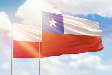Sunny blue sky and flags of chile and poland