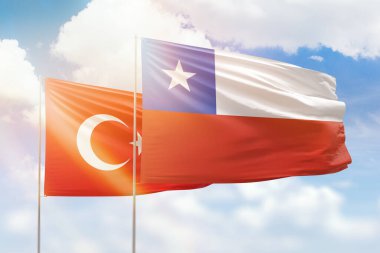 Sunny blue sky and flags of chile and turkey