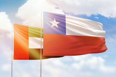 Sunny blue sky and flags of chile and uae