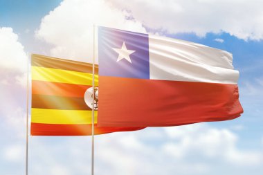 Sunny blue sky and flags of chile and uganda