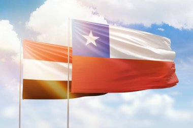 Sunny blue sky and flags of chile and yemen