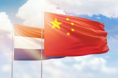 Sunny blue sky and flags of china and netherlands