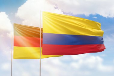 Sunny blue sky and flags of colombia and germany