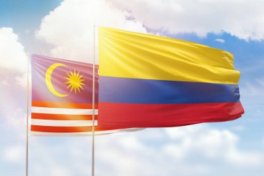 Sunny blue sky and flags of colombia and malaysia