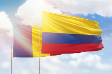 Sunny blue sky and flags of colombia and romania