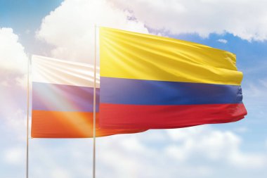 Sunny blue sky and flags of colombia and russia