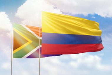 Sunny blue sky and flags of colombia and south africa