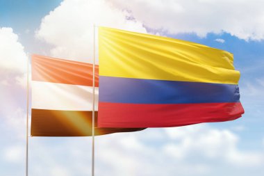 Sunny blue sky and flags of colombia and yemen