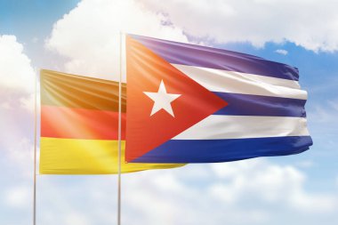 Sunny blue sky and flags of cuba and germany