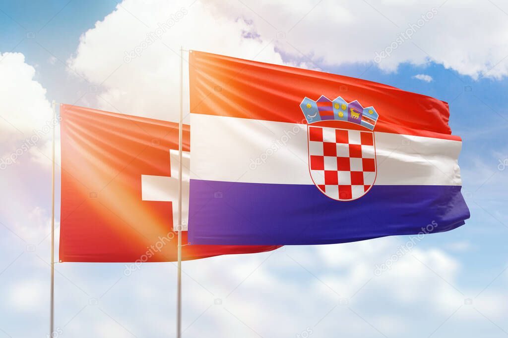 Sunny blue sky and flags of croatia and switzerland
