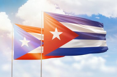 Sunny blue sky and flags of cuba and puerto rico